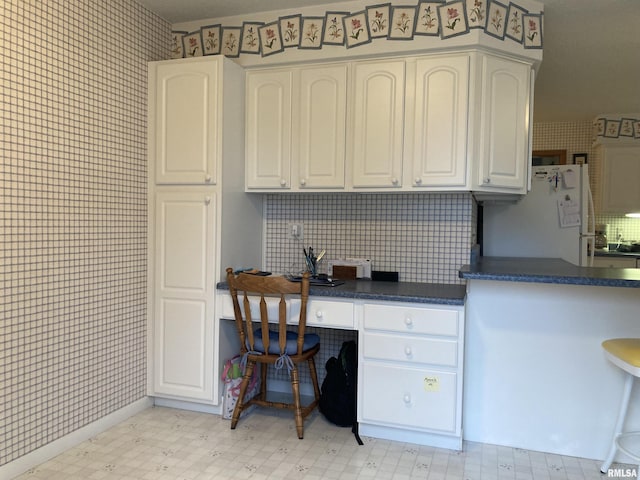 home office with baseboards, light floors, and wallpapered walls