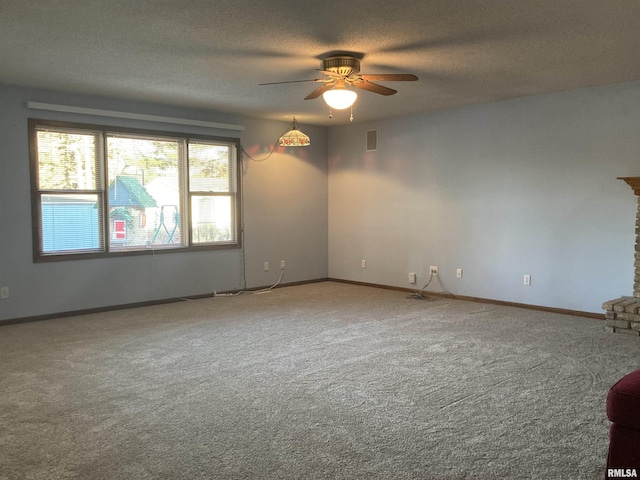 spare room featuring visible vents, baseboards, ceiling fan, carpet, and a textured ceiling