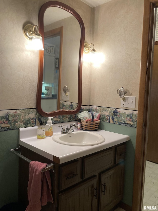 bathroom with wallpapered walls and vanity