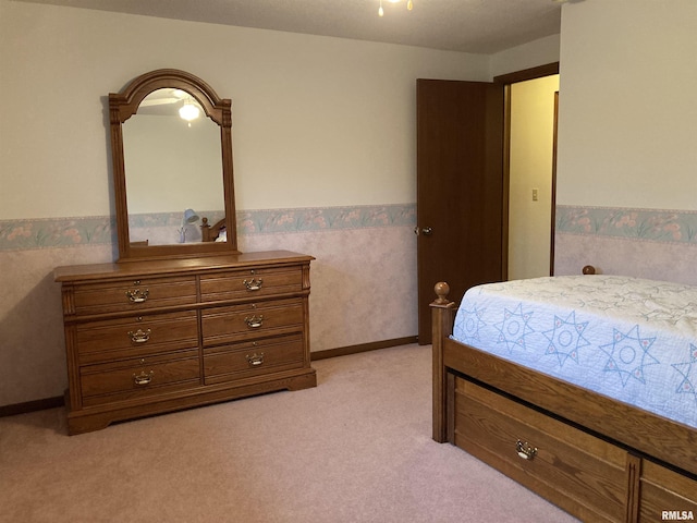 bedroom with a wainscoted wall and light carpet