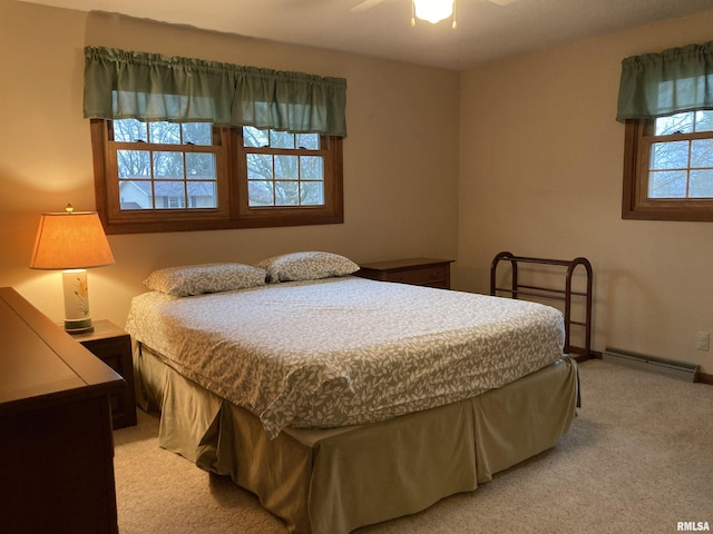 bedroom featuring light colored carpet, baseboards, baseboard heating, and ceiling fan