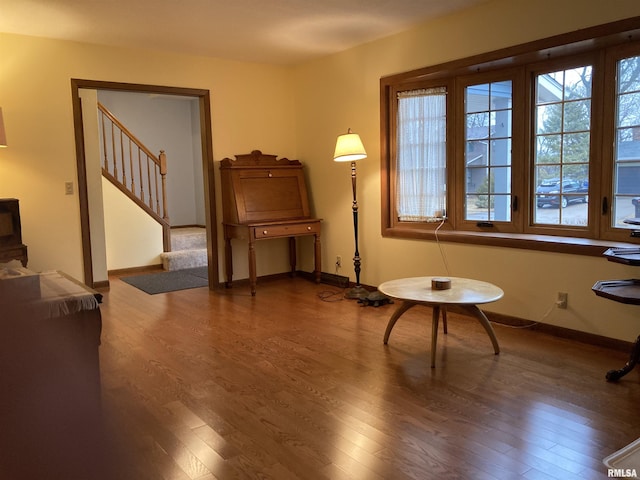 sitting room with stairway, baseboards, and wood finished floors