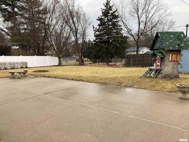 view of yard with a patio area, a storage unit, a fenced backyard, and an outdoor structure