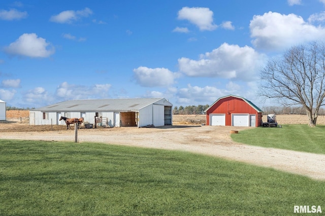 exterior space with a garage, driveway, a pole building, and an outdoor structure