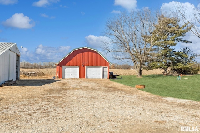 detached garage featuring dirt driveway