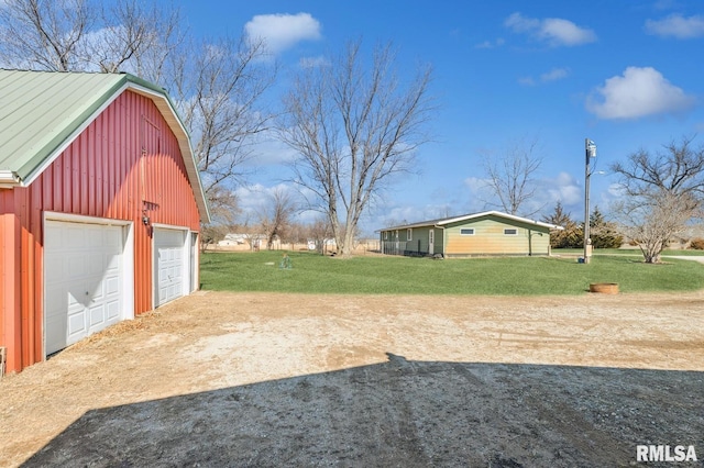 view of yard featuring a barn, a garage, and an outbuilding