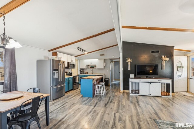 kitchen featuring visible vents, light wood-style flooring, lofted ceiling with beams, appliances with stainless steel finishes, and white cabinets