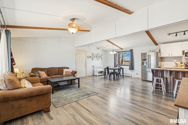 living room with vaulted ceiling with beams, baseboards, baseboard heating, and wood finished floors