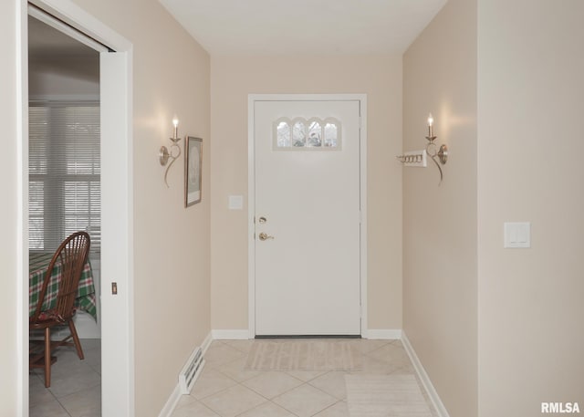 doorway featuring light tile patterned floors, visible vents, and baseboards