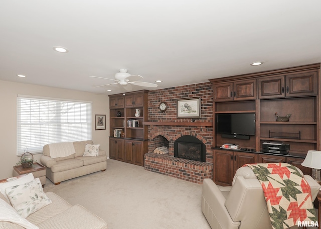 living room featuring a ceiling fan, recessed lighting, light carpet, and a fireplace