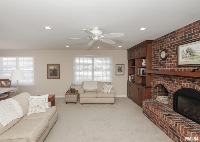 living room featuring light carpet, a brick fireplace, a wealth of natural light, and baseboards