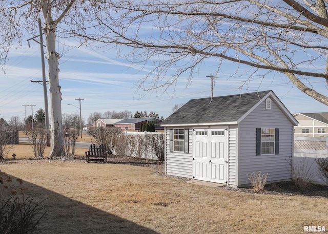 view of outdoor structure featuring an outbuilding and fence