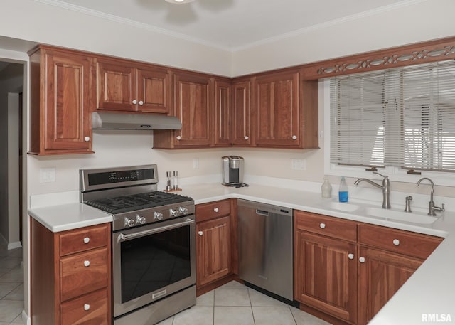 kitchen with appliances with stainless steel finishes, light countertops, crown molding, under cabinet range hood, and a sink