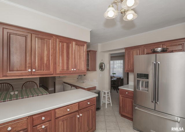 kitchen with light countertops, brown cabinets, high quality fridge, and light tile patterned floors