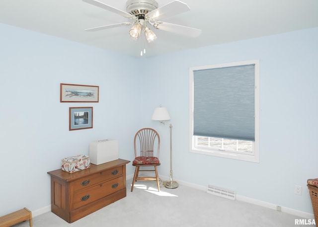 living area with carpet, visible vents, ceiling fan, and baseboards