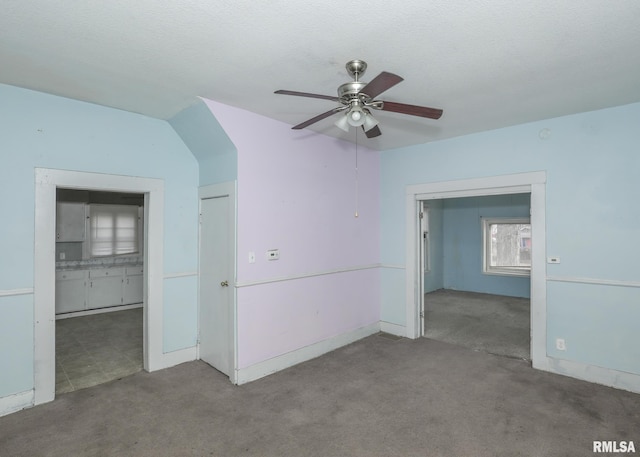 empty room featuring carpet floors, a textured ceiling, and a ceiling fan