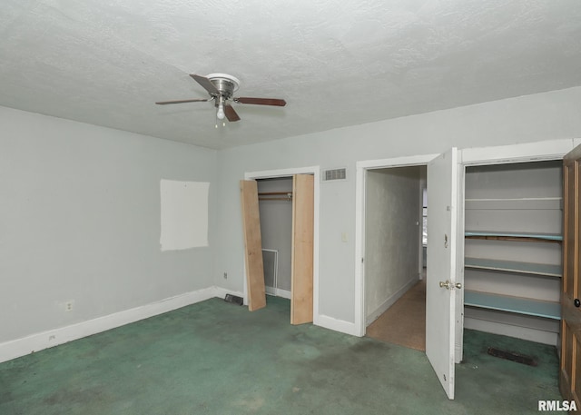 unfurnished bedroom with multiple closets, visible vents, a textured ceiling, and baseboards