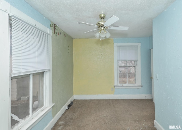 unfurnished room with a textured ceiling, a ceiling fan, visible vents, baseboards, and carpet