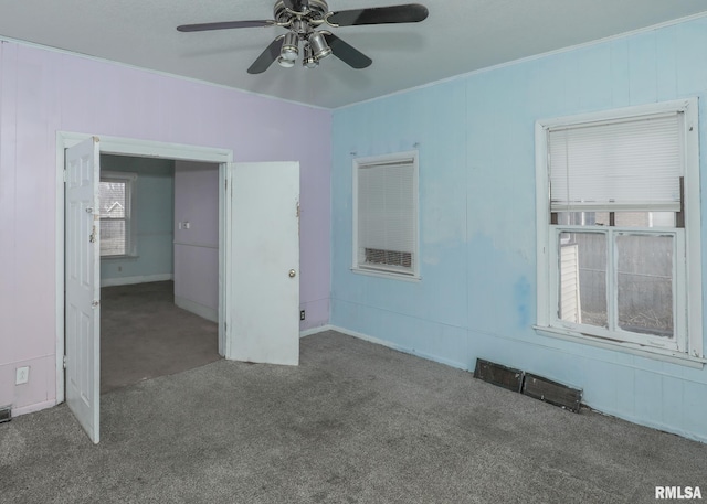 empty room with ceiling fan, carpet flooring, and crown molding