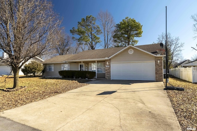 ranch-style house with a garage, brick siding, driveway, and fence