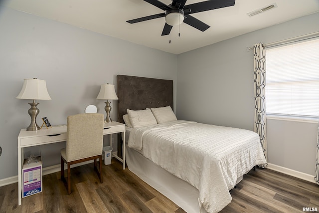 bedroom with ceiling fan, wood finished floors, visible vents, and baseboards