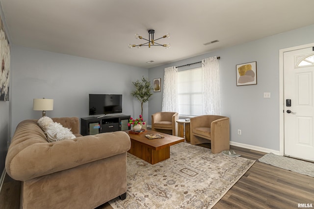 living area with wood finished floors, visible vents, and baseboards