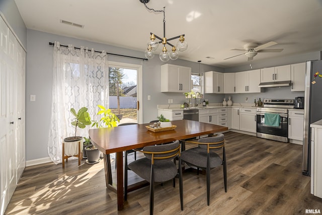 dining area with baseboards, visible vents, dark wood-style flooring, and ceiling fan with notable chandelier