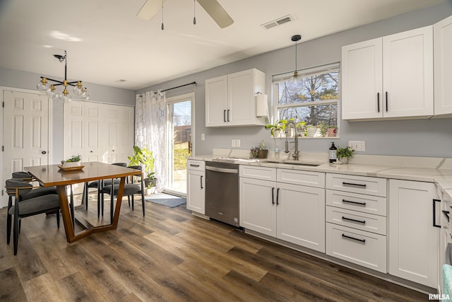 kitchen featuring visible vents, dark wood-type flooring, white cabinets, a sink, and dishwasher