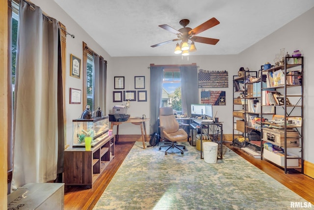 office area with wood finished floors, a ceiling fan, and baseboards