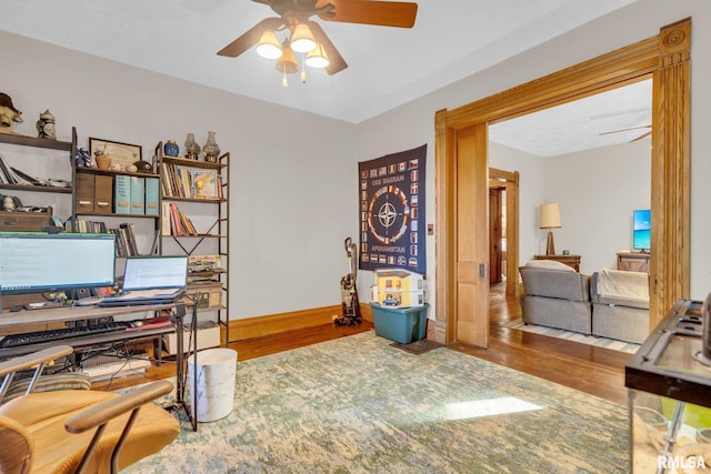 home office with ceiling fan, baseboards, and wood finished floors