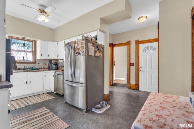 kitchen with white cabinets, decorative backsplash, ceiling fan, stainless steel appliances, and a sink