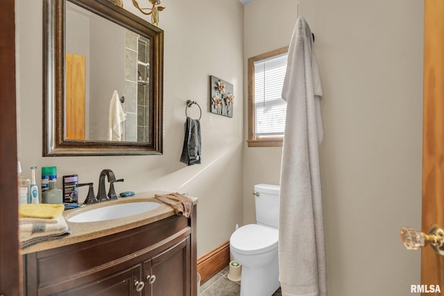 bathroom with tile patterned floors, vanity, toilet, and baseboards