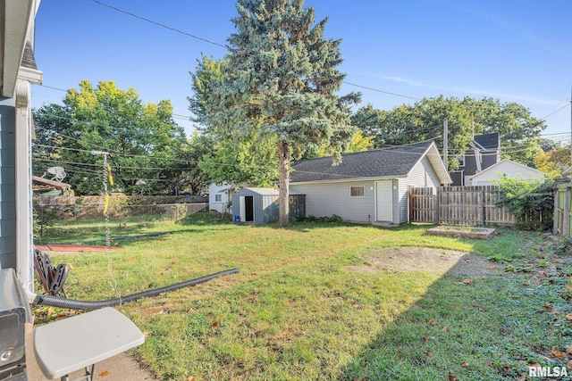 view of yard with an outbuilding, a shed, and a fenced backyard