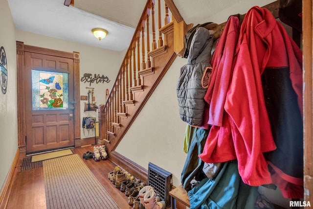 entryway featuring stairs, baseboards, and hardwood / wood-style flooring