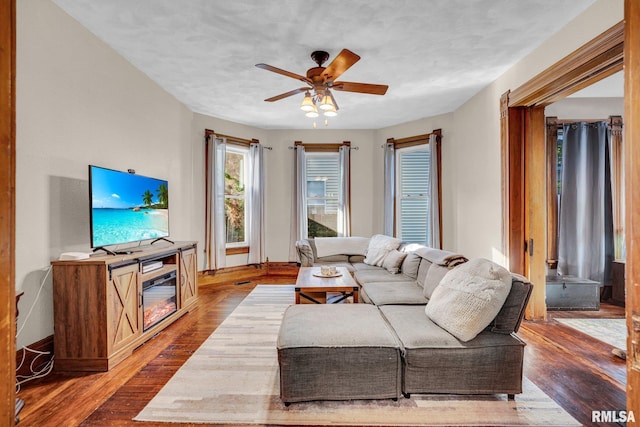 living area with wood finished floors and a ceiling fan