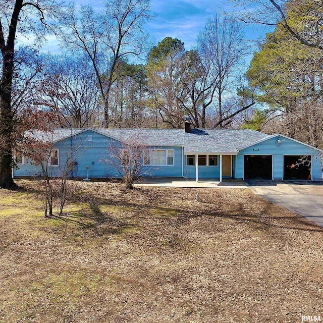 ranch-style home with a chimney and an attached garage