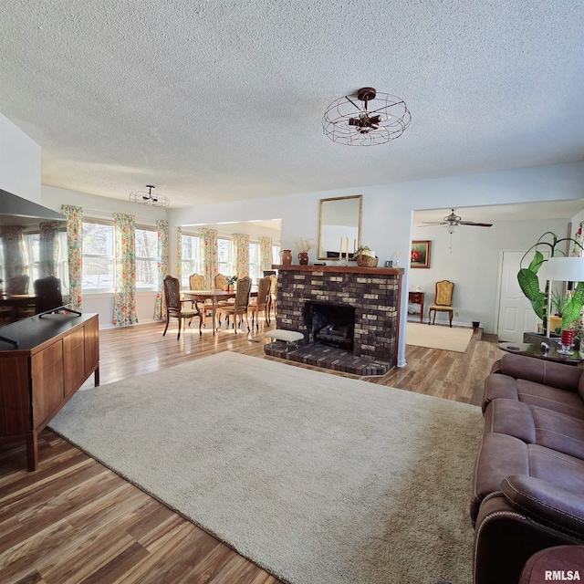 living area featuring a textured ceiling, a fireplace, and wood finished floors