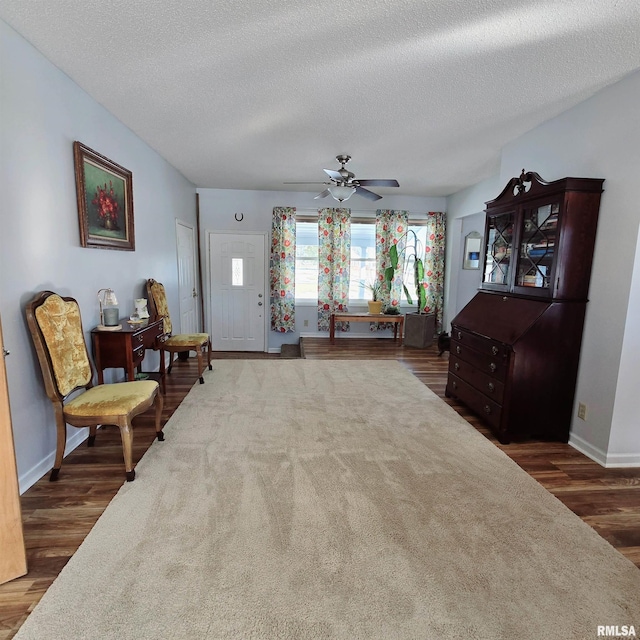 foyer featuring ceiling fan, baseboards, and wood finished floors