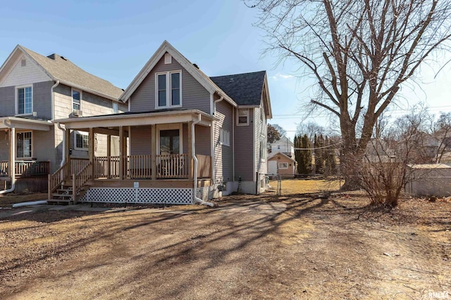 exterior space with a shingled roof, fence, and a porch