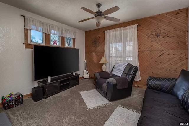 unfurnished living room with a ceiling fan, carpet, wood walls, and a textured ceiling