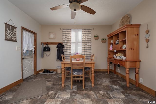 dining room with stone finish flooring, baseboards, and a textured ceiling