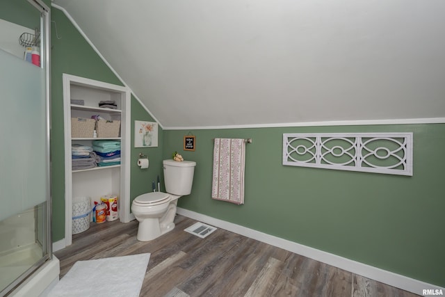 bathroom featuring visible vents, vaulted ceiling, a shower stall, wood finished floors, and baseboards