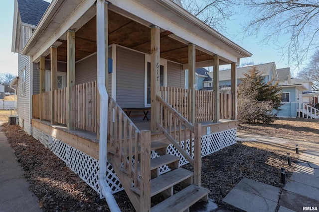 property entrance with central air condition unit, covered porch, and roof with shingles