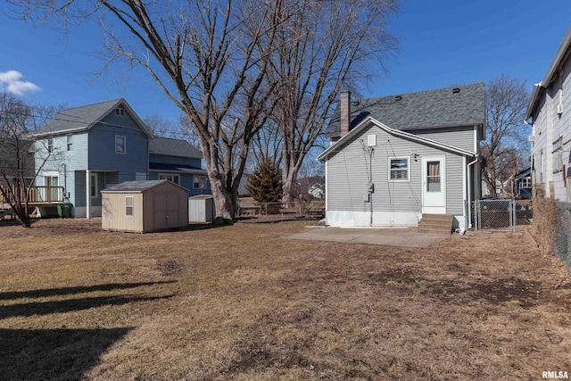 view of yard featuring a storage shed, entry steps, a gate, fence, and an outdoor structure