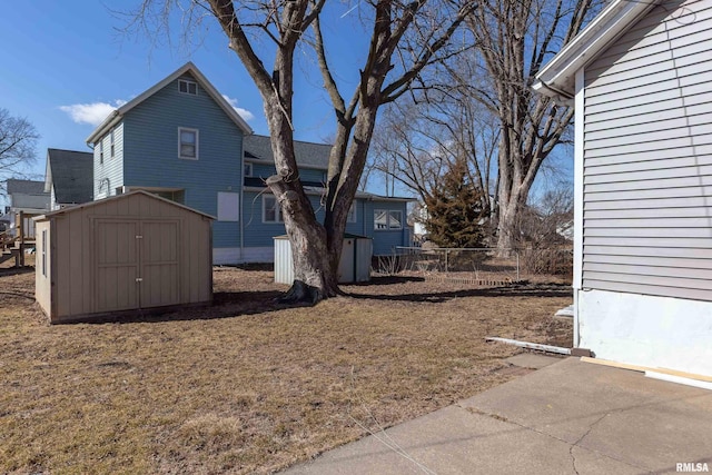 view of yard featuring an outdoor structure, fence, and a storage unit