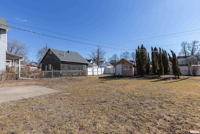 view of yard featuring an outbuilding and fence