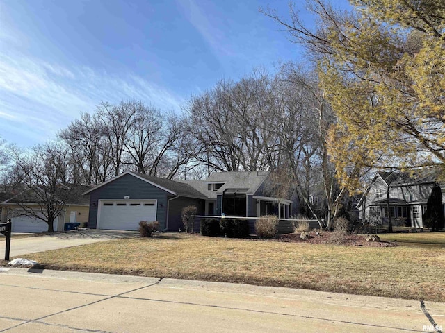 view of front of home featuring concrete driveway, a front lawn, and an attached garage