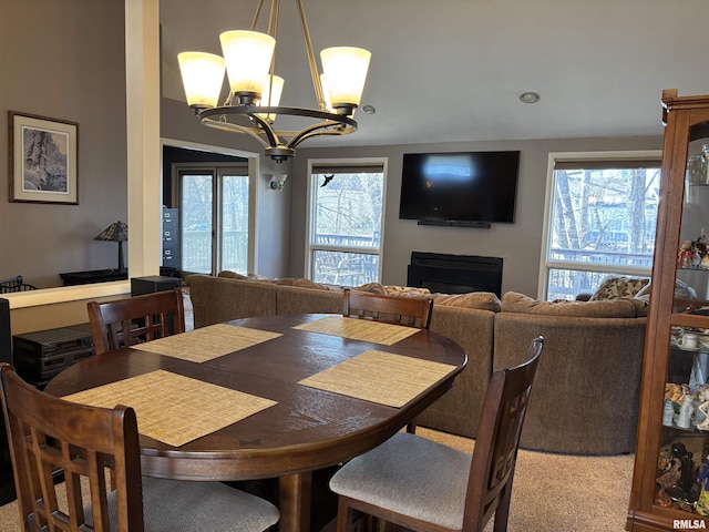 dining room with a chandelier and a fireplace