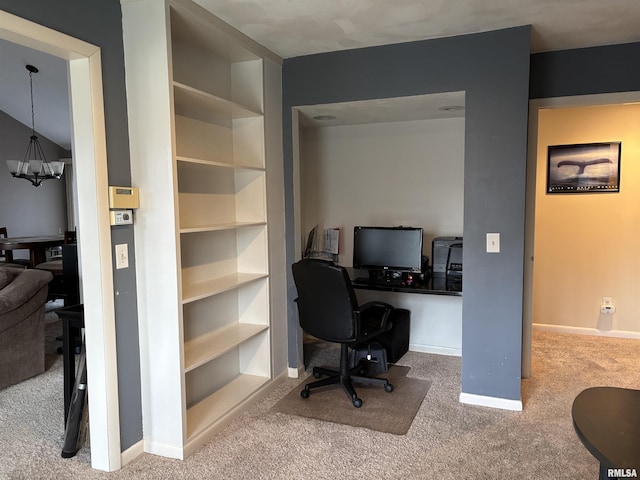 carpeted office space featuring a notable chandelier and baseboards