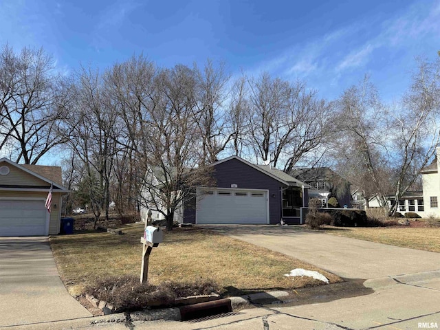 view of front of house featuring a garage, concrete driveway, and a front lawn